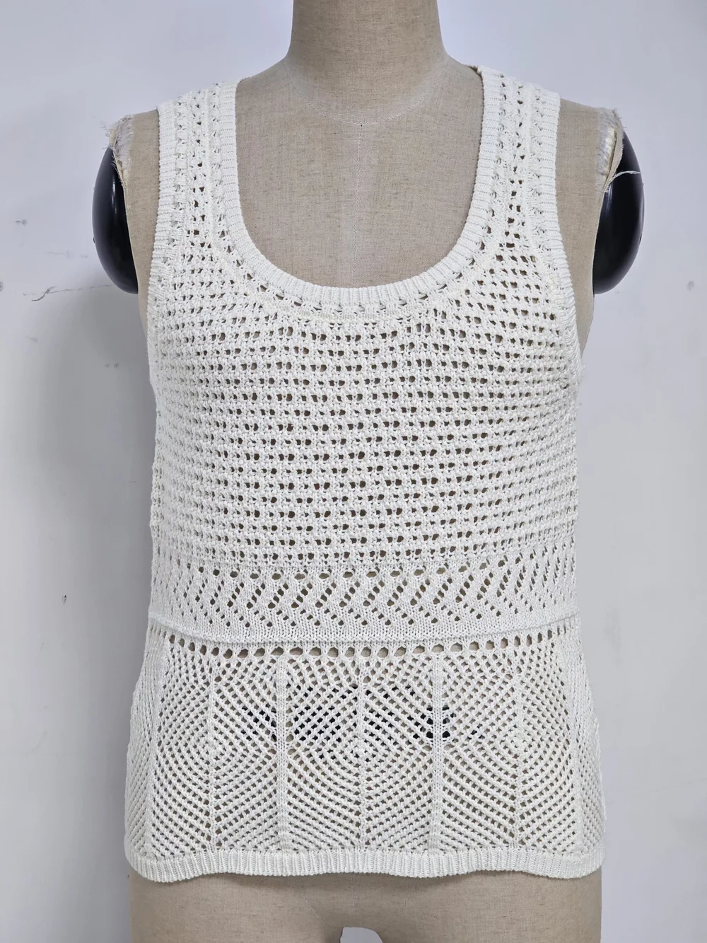 White knit top combining geometric openwork zones and shaped edges